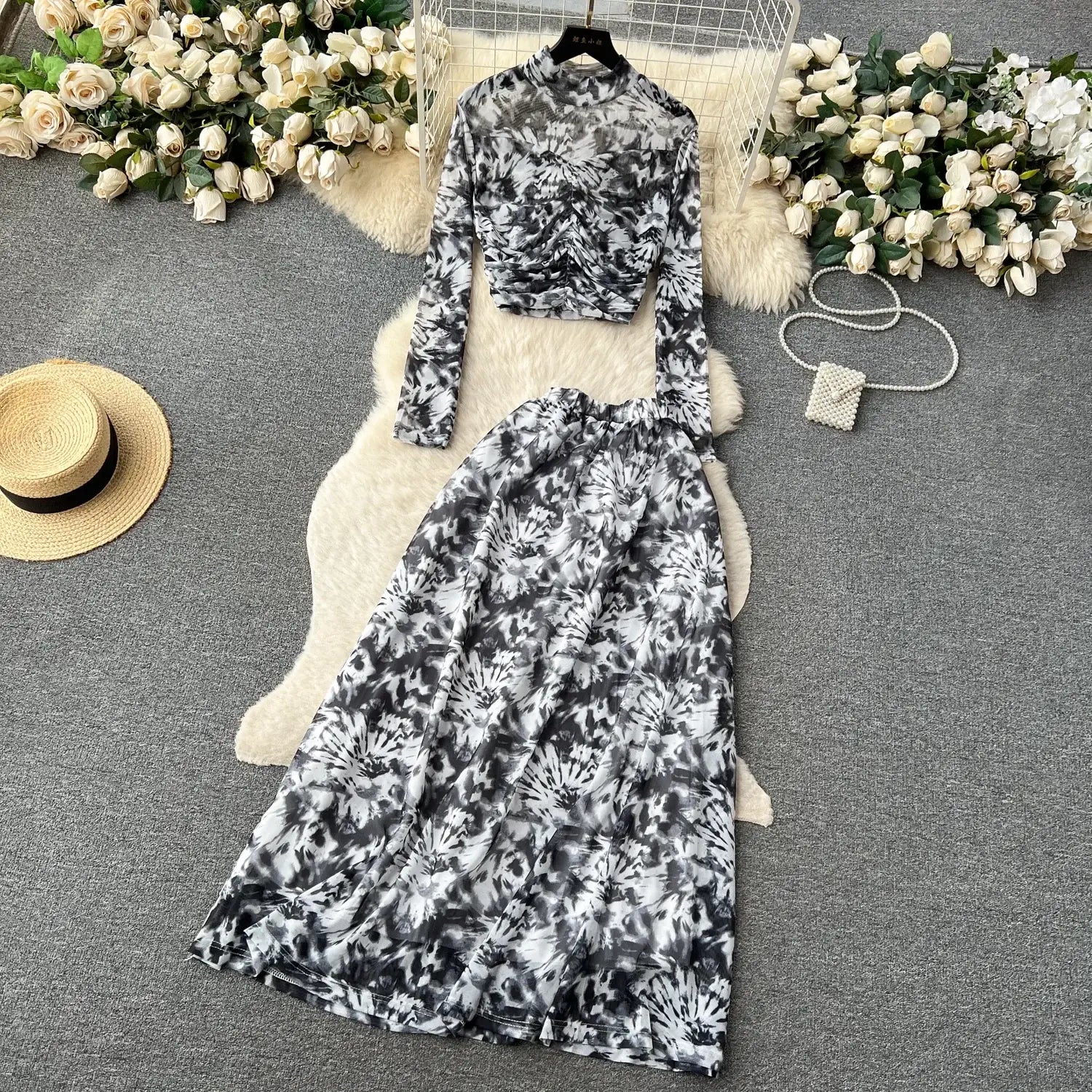 black and white tie-dye two piece mesh skirt set featuring a long-sleeved ruched crop top and flowing maxi skirt with elastic closure type in marble print