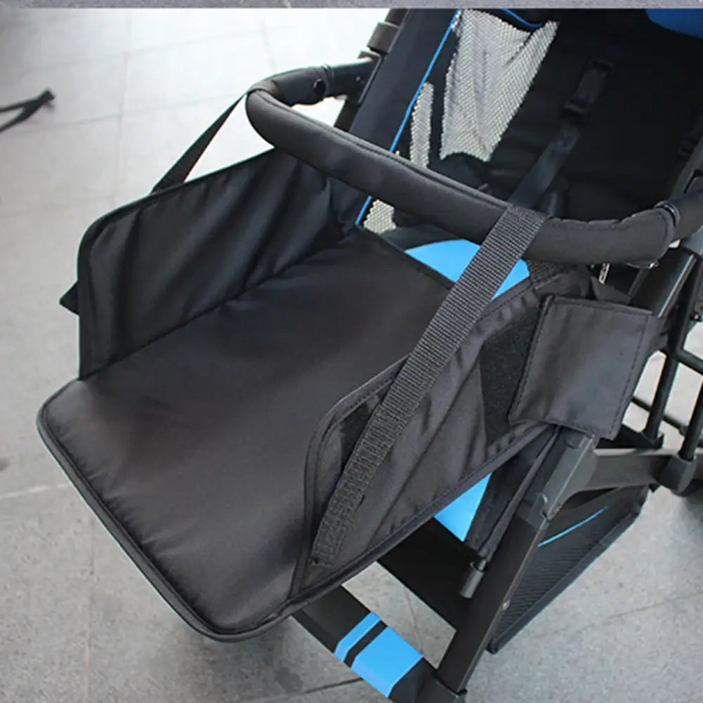 Black fabric universal stroller extension footrest with adjustable straps and a small pocket designed as a seat organizer for infants