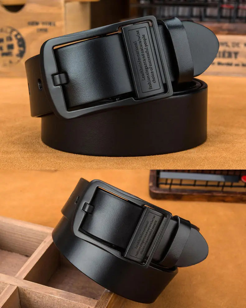 Black leather belt with a matte black metal buckle featuring engraved text suitable for casual jeans.