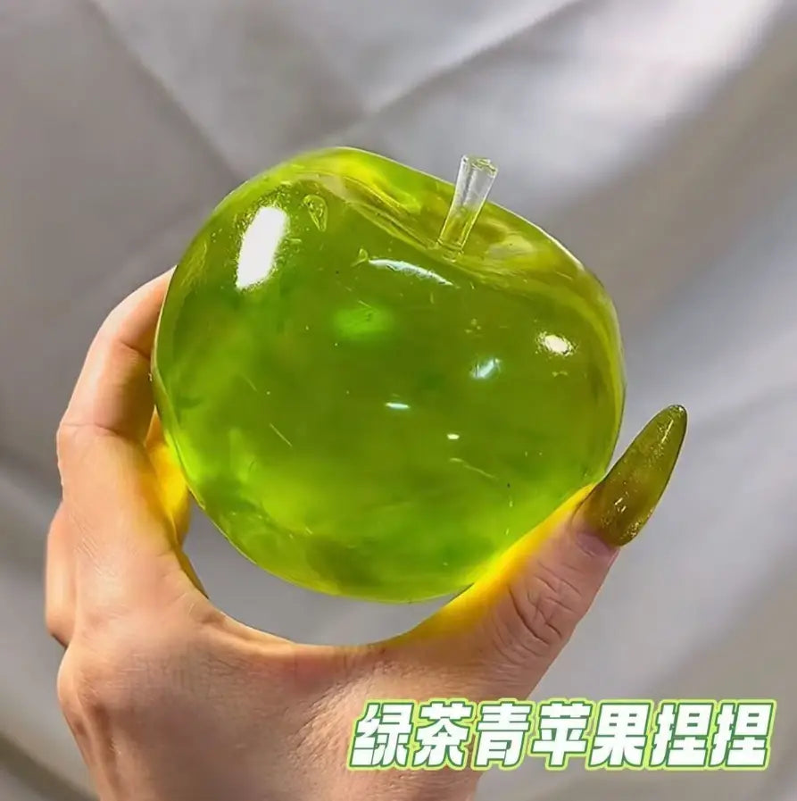 une balle anti-stress souple verte en forme de pomme vert citron translucide, avec une tige transparente en matériau de type gel, vue de face
