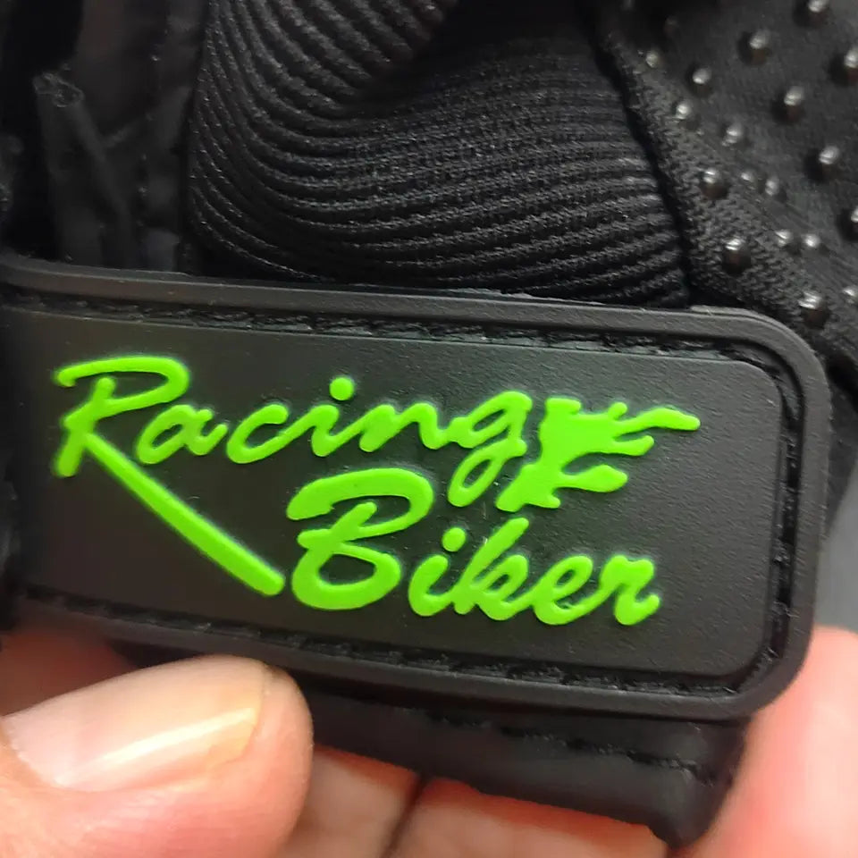 Black rubber patch with neon green racing biker logo in cursive script on the back side of breathable protective motorcycle racing gloves.