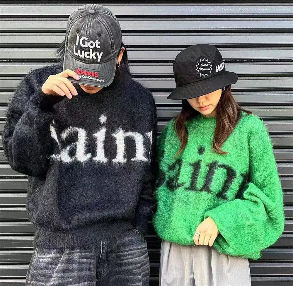 フワフワとした素材で作られ、正面に白いsinの刺繍文字が施されたブラックのオーバーサイズニットセーター。