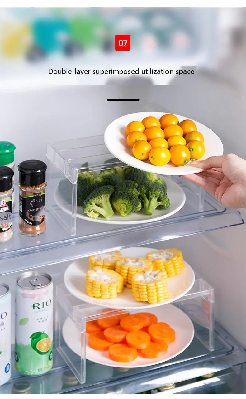 clear expandable cabinet organizer and spice rack featuring a clear acrylic refrigerator shelf with a transparent tiered design holding plates of vegetables and fruit