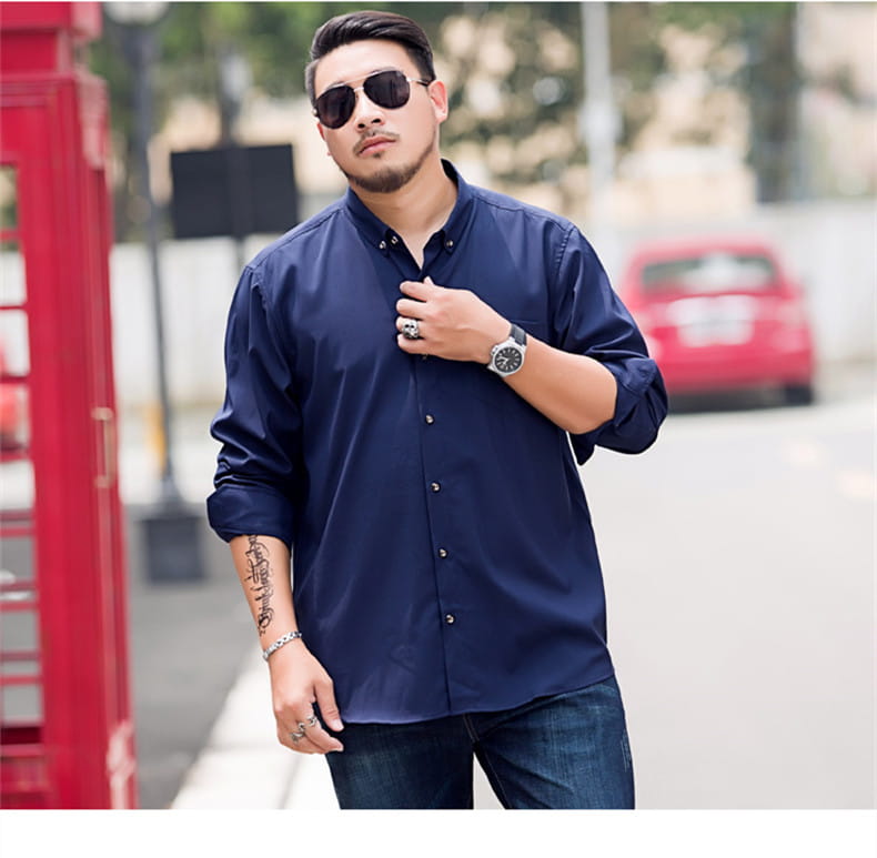 Chemise habillée pour hommes, grande taille, bleu marine, manches longues, avec col à boutons-pression et manches retroussées, adaptée à une tenue de travail formelle.