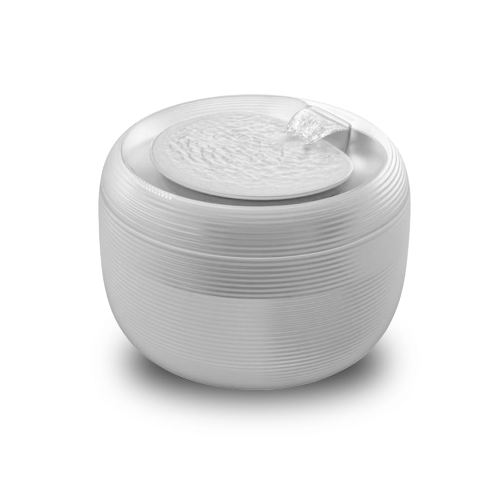 Un dispensador de agua para gatos de cerámica blanca con ligeras ondulaciones horizontales y una tapa texturizada, mostrado desde la parte frontal