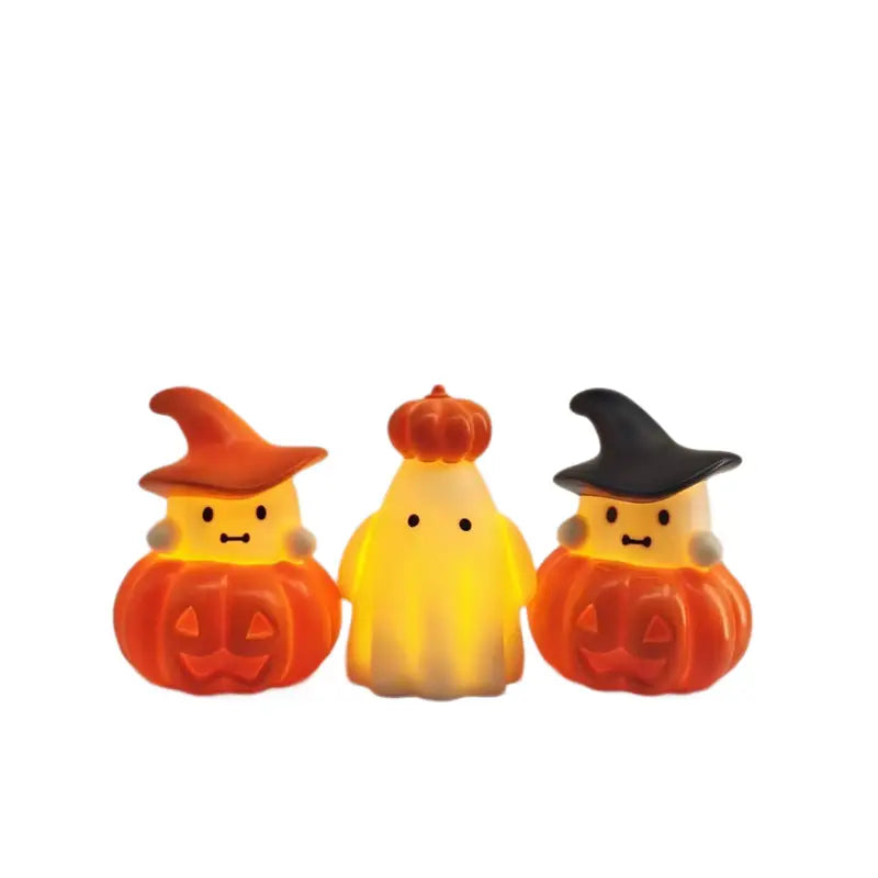 three cute halloween-themed led light figures featuring a glowing orange pumpkin with an orange witch hat on the left and right flanking a central yellow ghost figure topped with a small orange pumpkin in a halloween pumpkin ghost night light ornament