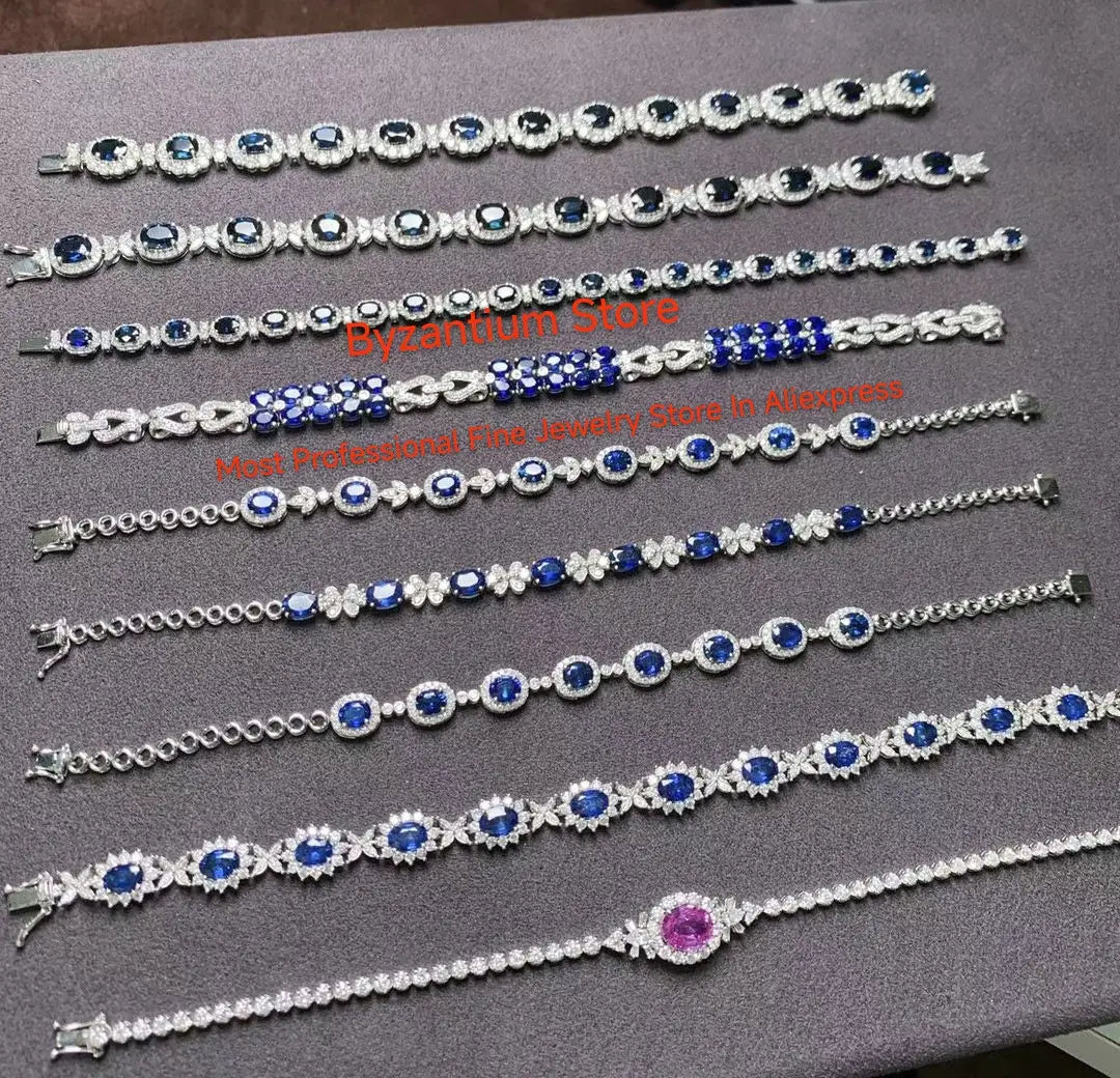 Eine Sammlung eleganter Armbänder in Silberton mit blauen und weißen Edelsteinen, mit aufwendigen Designs: ovale Saphire, umgeben von Diamanten, sowie Ohrringe mit silbernen Tropfenquasten in Gold-Vermeil.