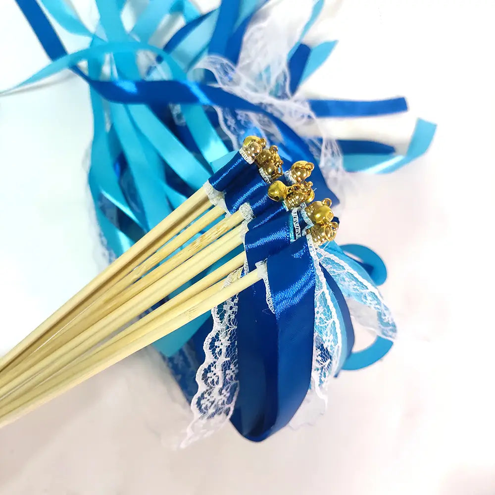 Baguette de ruban de mariage enveloppée d’un ruban en satin bleu avec des breloques d’ours dorées et une bordure en dentelle blanche, conçue pour les mariages.