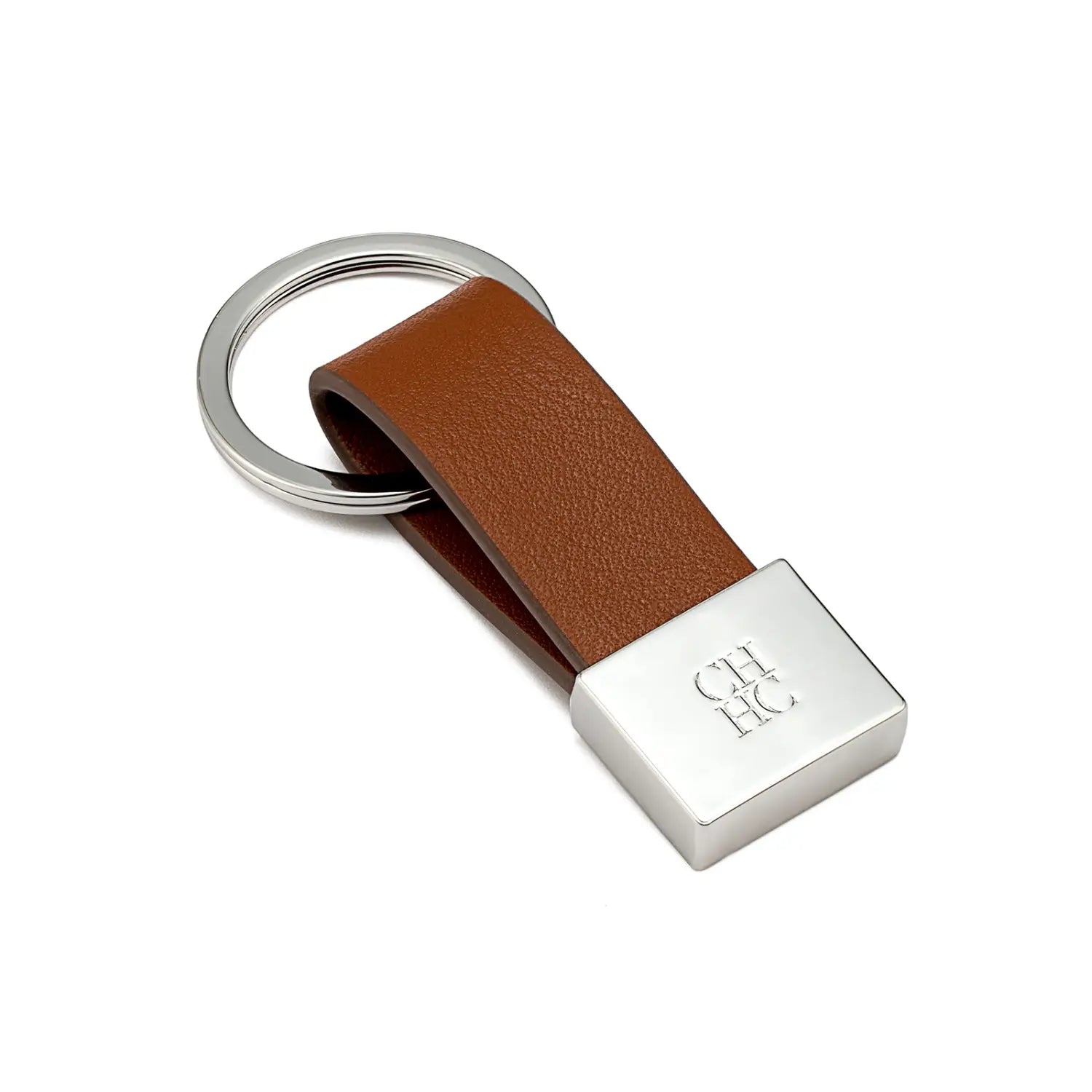 Porta llaves de cuero marrón con una placa metálica de tono plateado grabada con ch hc, sujeta a un anillo circular; accesorio de equipaje minimalista.