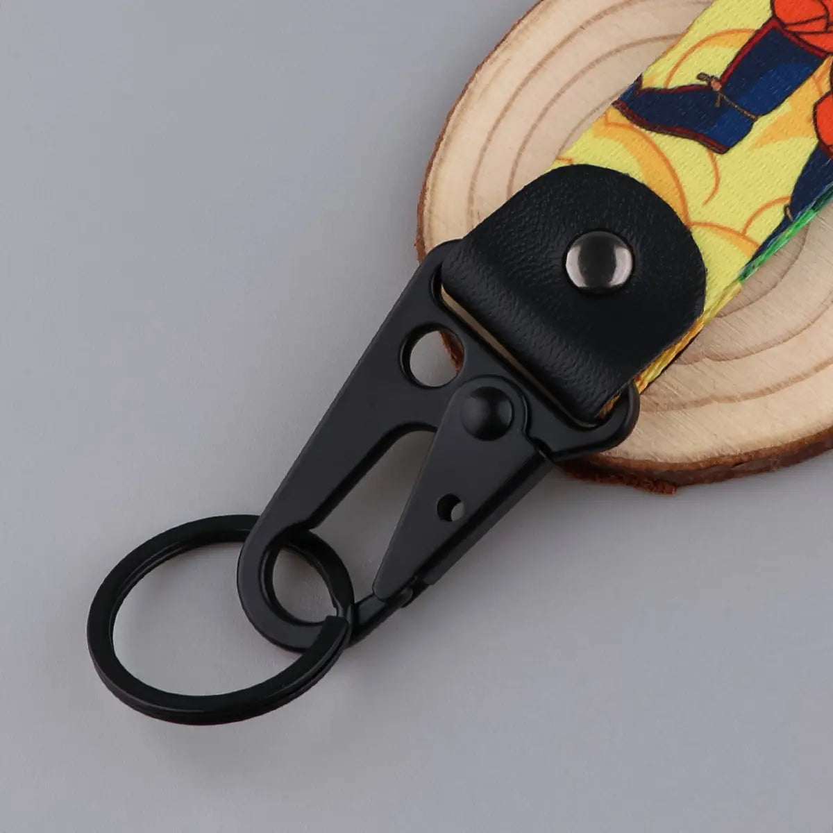 Black metal carabiner keychain with a colorful printed fabric strap featuring an illustrated Goku and Vegeta character design from Dragon Ball Z.
