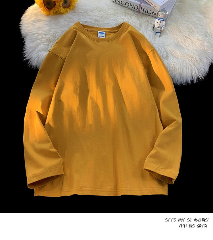 A mustard-yellow oversized long sleeve blank t-shirt made of cotton featuring a simple crew neck design.