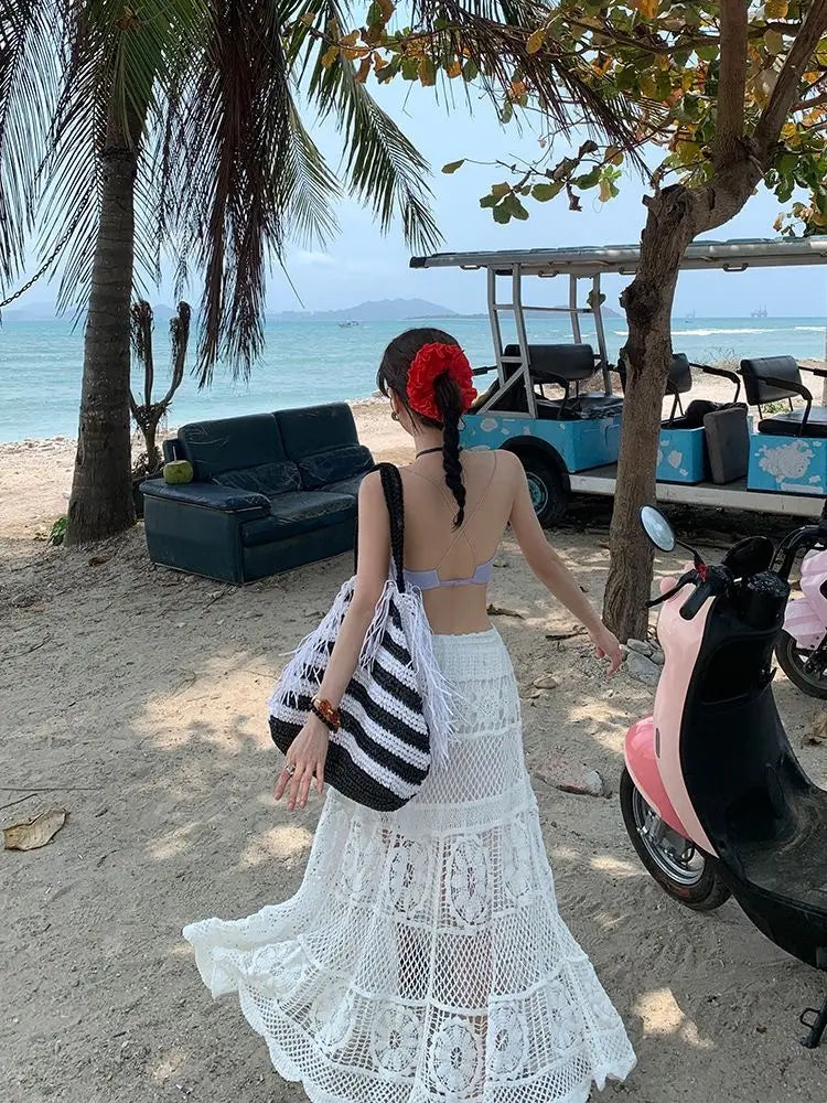 White crochet lace maxi skirt featuring tiered layers and a flowing airy design perfect for summer wear