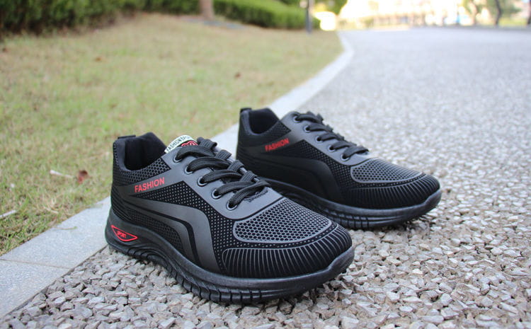 Men breathable athletic sneakers running shoes in black with red accents and a mesh upper featuring the word fashion in red lettering on the side.