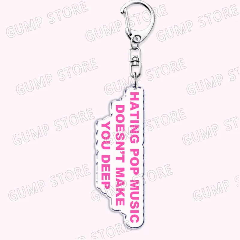 A pink acrylic Tate Mcrae keychain featuring bold white text hating pop music doesnt make you deep with a silver metal clasp and chain designed as a music fan gift.
