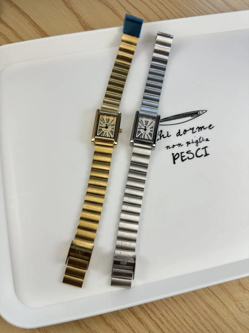 Two elegant vintage gold rectangular quartz watches for women with gold and silver-toned ridged metal bracelets.
