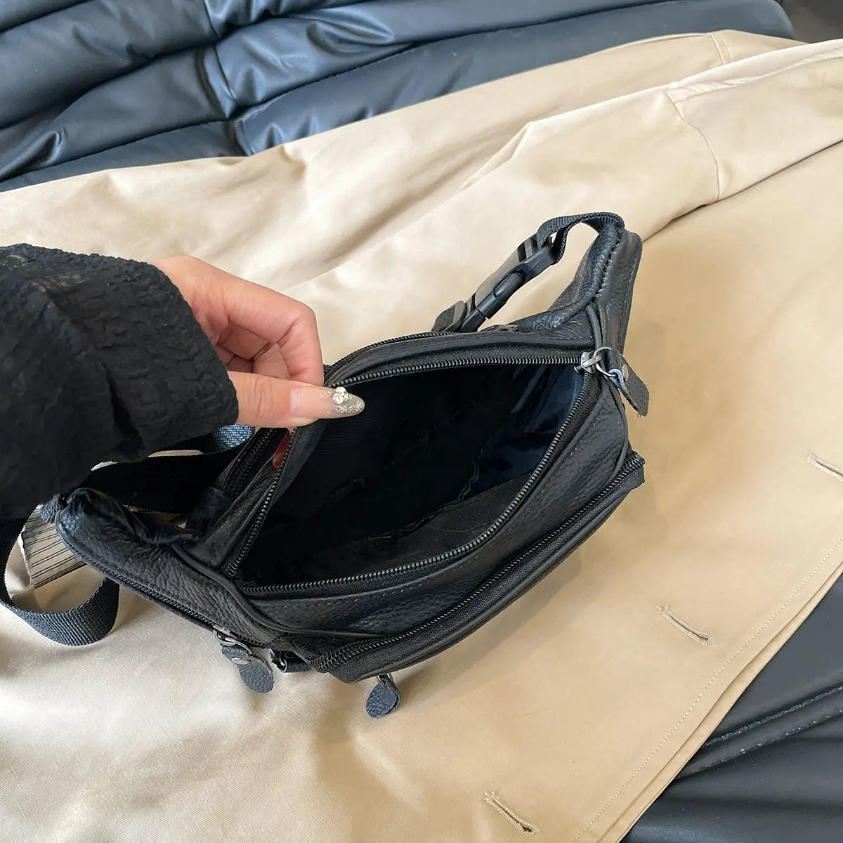 Gürteltasche aus echtem Leder in Schwarz mit mehreren Reißverschlüssen und einem verstellbaren Riemen für die vielseitige Verwendung als Crossbody- oder Bauchtasche.