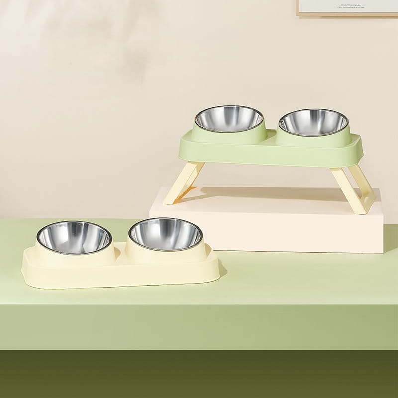 set of two pastel green elevated pet feeding stations with stainless steel tilt bowls designed for ergonomic feeding.