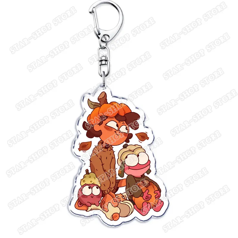 Clear acrylic Amphibia anime keychain featuring cartoon characters in autumn-themed outfits with a silver metal clasp.