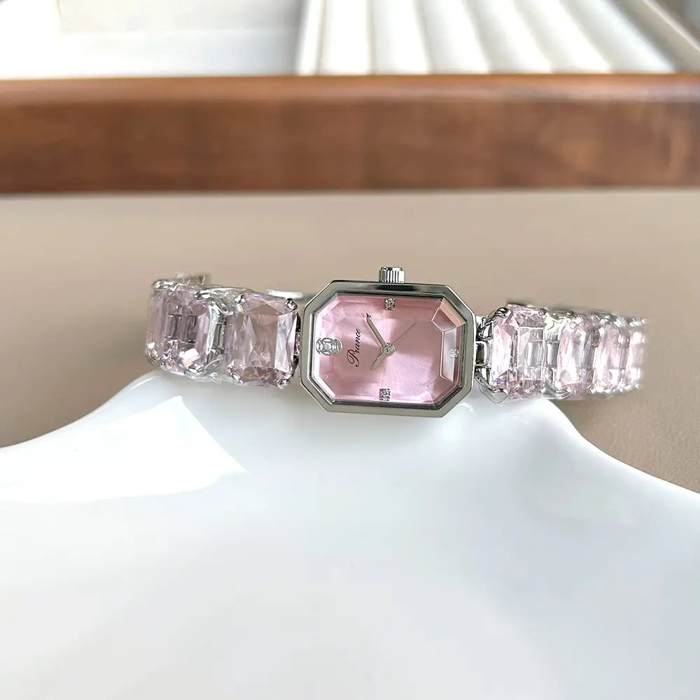 A delicate pink octagonal women quartz crystal watch with a silver-toned case and band adorned with sparkling faceted crystal-like stones.