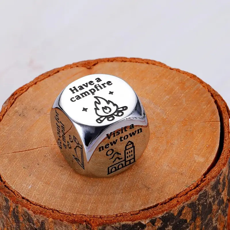 Silver-toned stainless steel cube-shaped food decision dice ring with engraved camping-themed phrases and illustrations for couples date night.