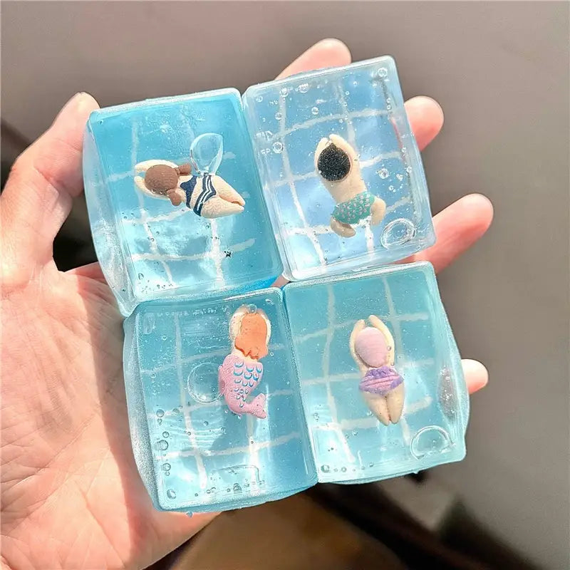 cube sphérique translucide bleu à faible rebond, visqueux et lent, transparent, renfermant de petites poupées de maillots de bain et des décorations en forme de bulles, vu de face