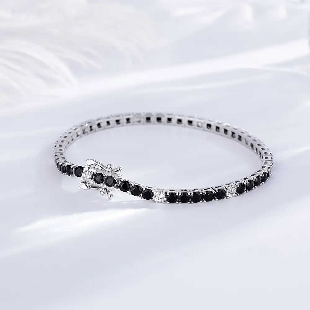 Sterling silver black cz tennis bracelet featuring a 3mm polished metal band adorned with round-cut black and clear gemstones.