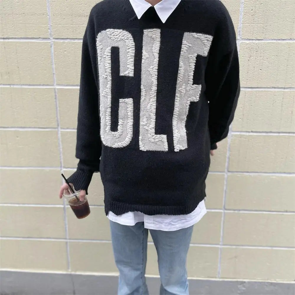 sin刺繍コレクションの、太いシルバーの「glf」レタリングとテクスチャデザインを施したブラックのオーバーサイズニットセーター。