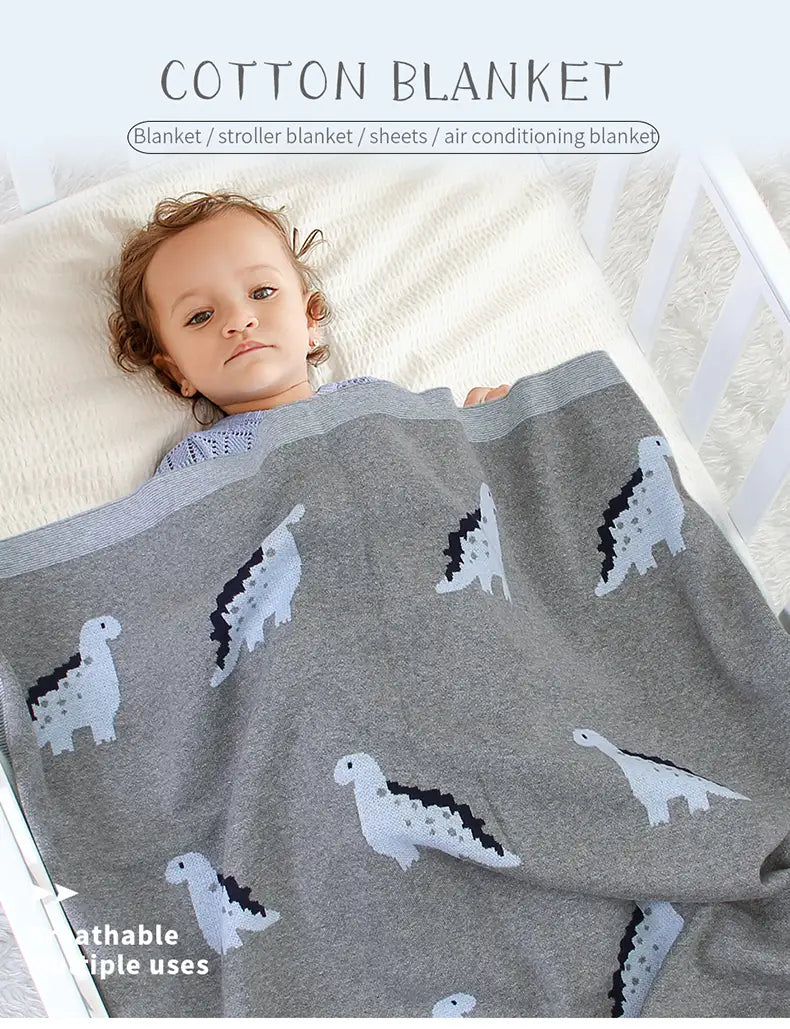 Graue Baumwoll-Jersey-Babyddecke mit weißen und schwarzen Dinosaurier-Mustern, entworfen als Wickeldecke für das Gitterbett.