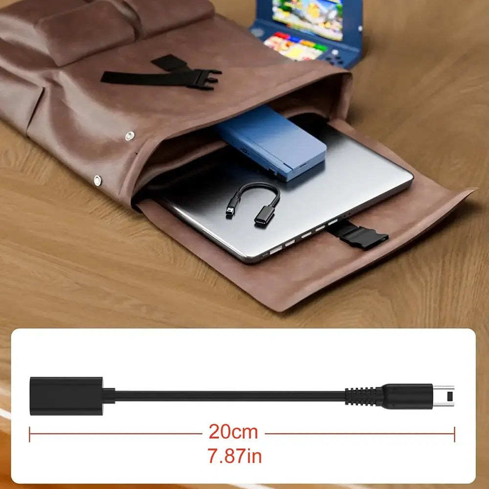 Funda para portátil de cuero marrón con botones a presión plateados y detalles de correa negra, que contiene un portátil plateado y un power bank azul, ilustrando un cable de carga USB C para el producto Nintendo 3DS DSi 2DS XL.