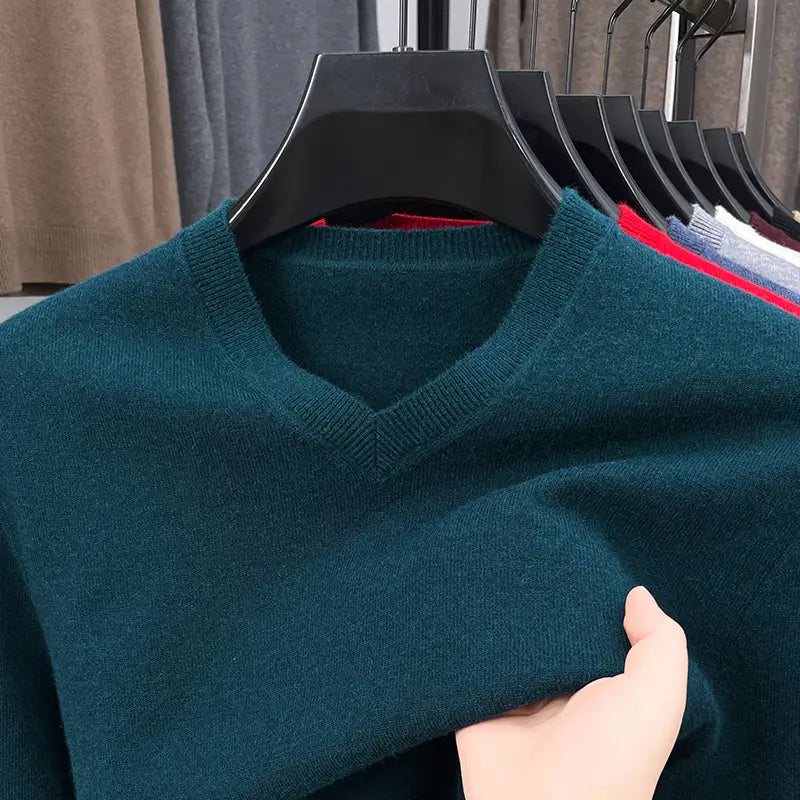Herren-V-Ausschnitt-Strickpullover in tiefem Petrol mit weicher, gerippter Strickstruktur, auf einem schwarzen Kleiderbügel hängend.