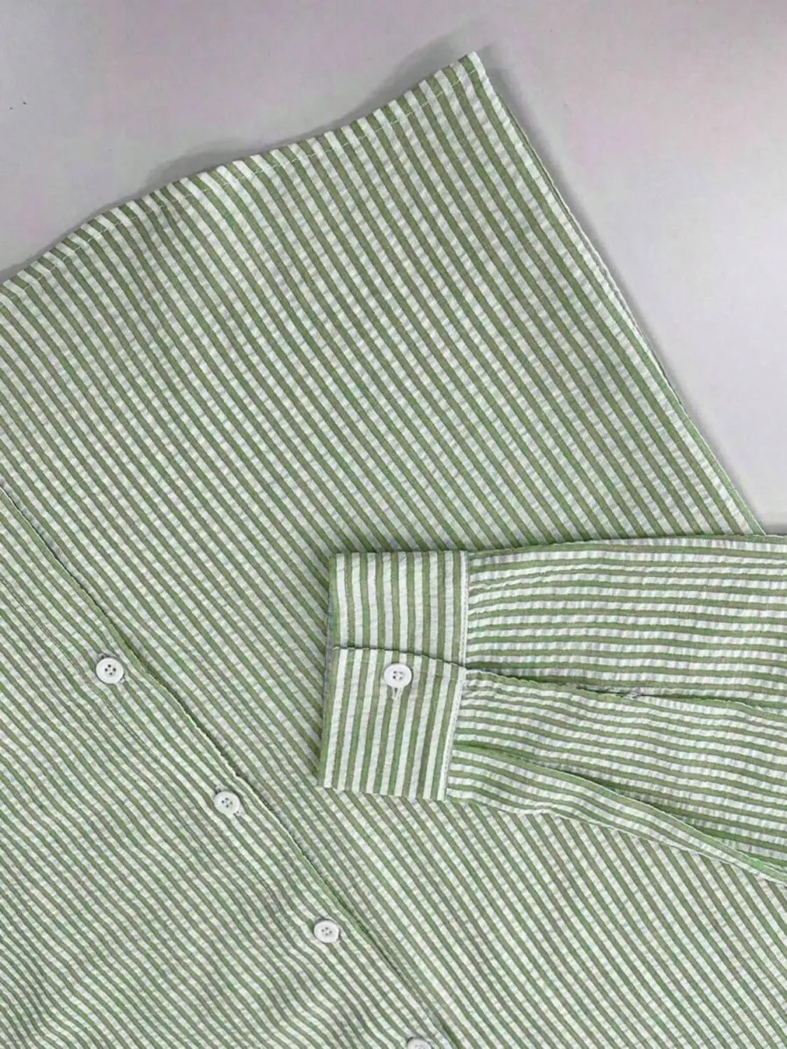 Chemise décontractée boutonnée manches longues à rayures bleues pour homme, avec des rayures verticales vert clair et blanc, et un tissu texturé net.