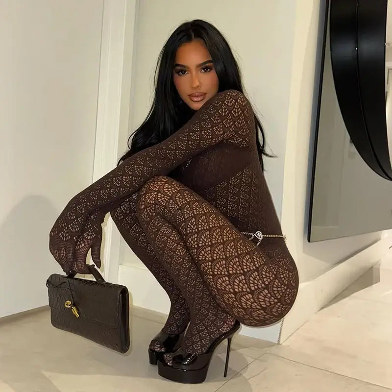black textured handbag with gold-tone hardware paired with fishnet see through long romper for a stylish and modern look