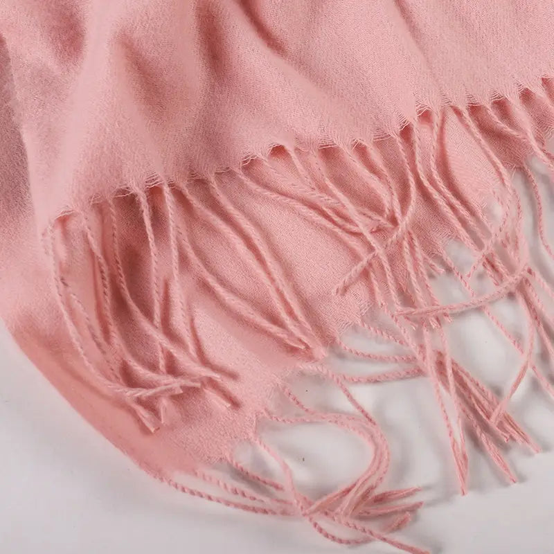 やわらかなピンクの女性用カシミヤ風冬用スカーフ／ショールです。カシミヤ素材で作られており、繊細なフリンジ付きの縁があります。