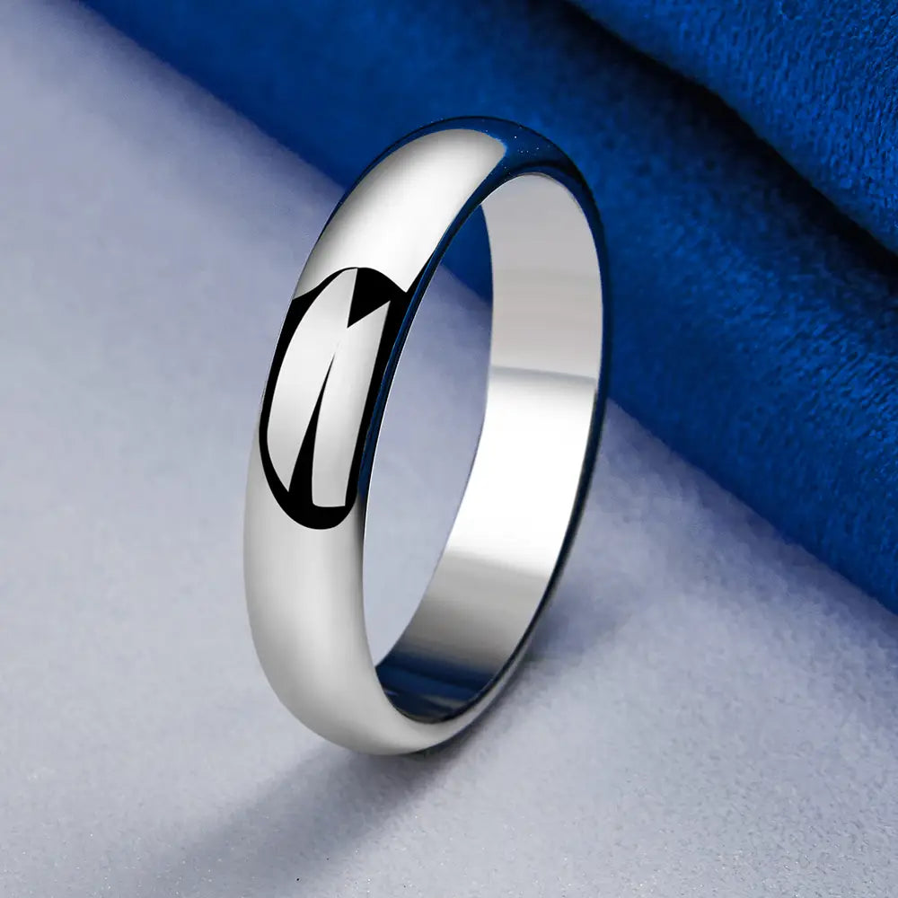 A sleek silver band ring made of 925 sterling featuring a minimalist black engraved design on its polished surface.