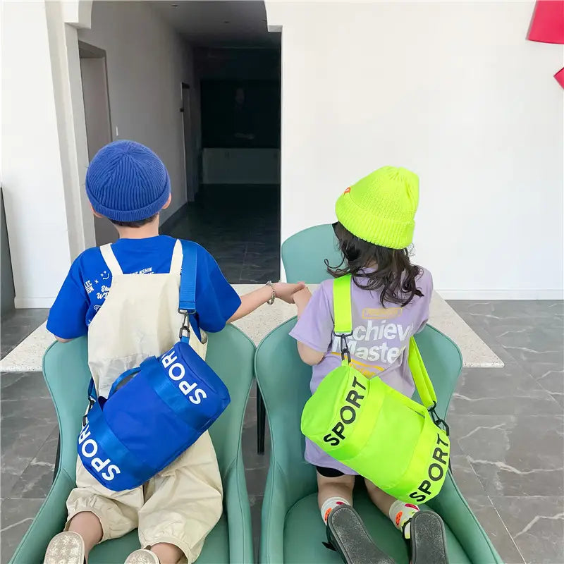 Kinder-Sport-Reise-Sporttasche in Blau und Neon-Grün mit kräftiger weißer Sportbeschriftung, entworfen für Reise-, Gym- und Crossbody-Nutzung.