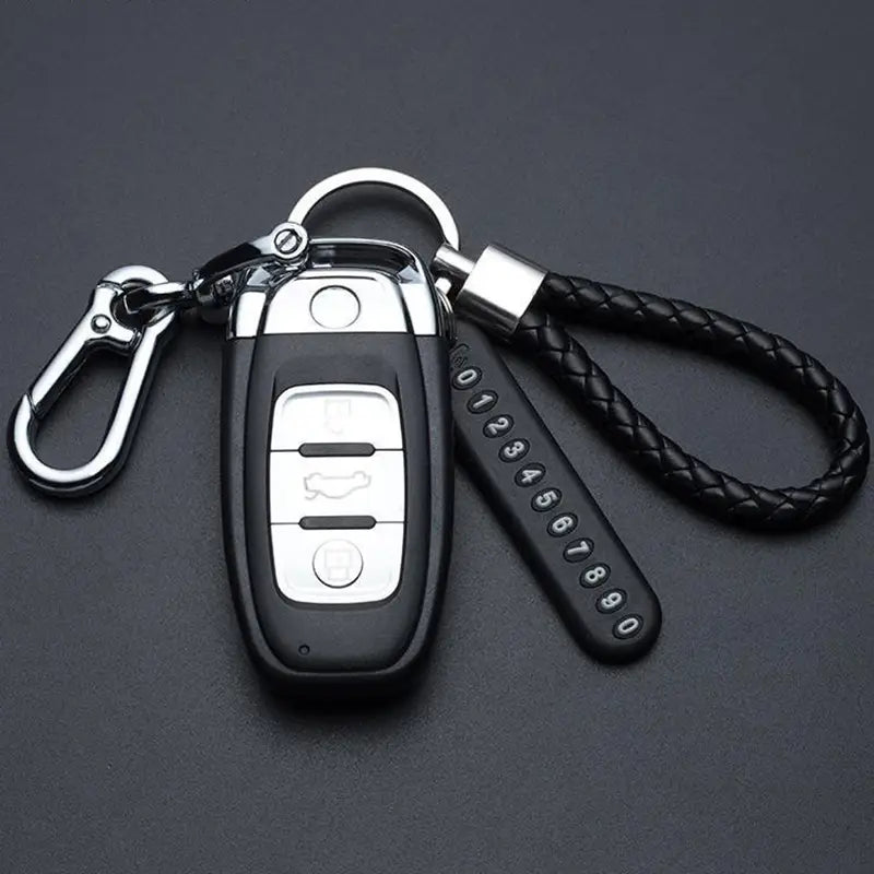 Black leather anti-lost stainless steel car key ring pendant with silver buttons, chrome accents, braided black cord, and metal carabiner.