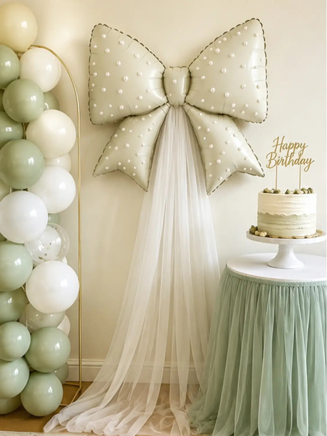 Un grand nœud décoratif pour ballon de mariage de couleur crème, avec un motif à points et des ornements évoquant des perles, provenant d’un ensemble de décoration en tulle.