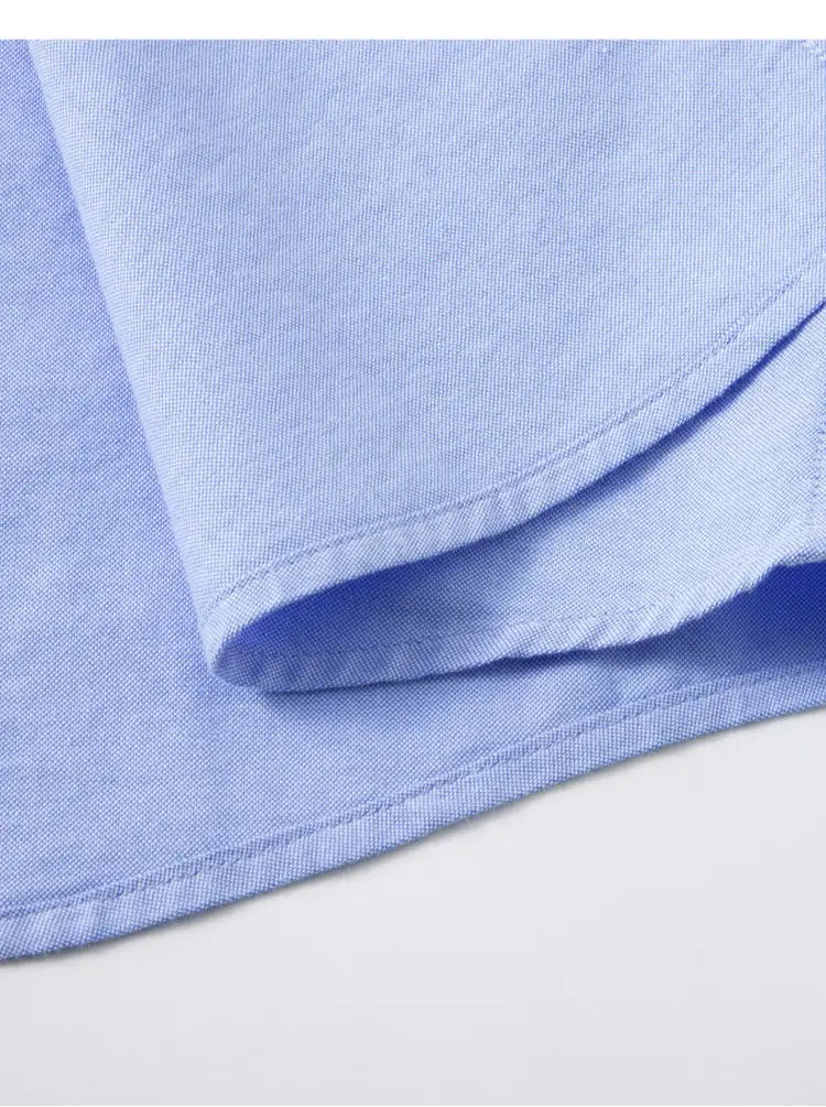 Tela de la camisa Oxford de algodón color azul claro, corte slim fit, para hombre, con textura tejida sutil y bordes cosidos con esmero.