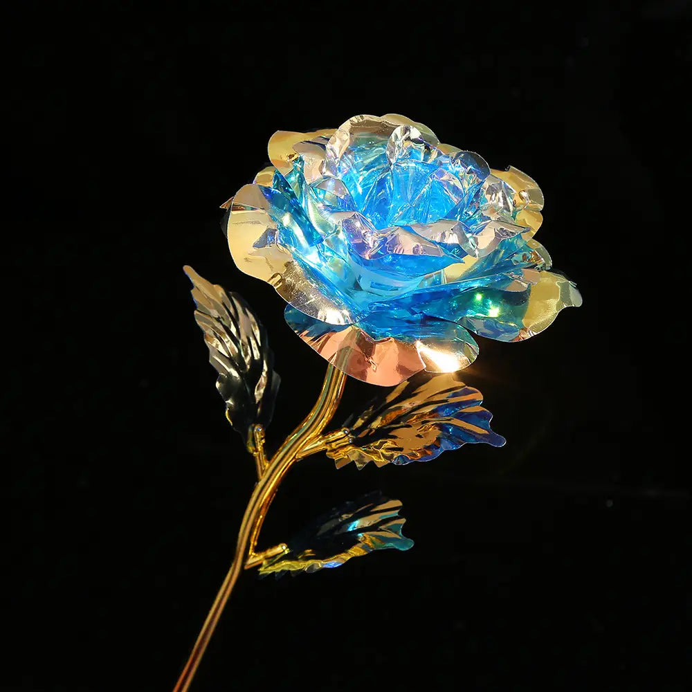 A glowing blue and gold metallic rose with intricate petal details in the gold foil artificial rose eternal gift flower product.