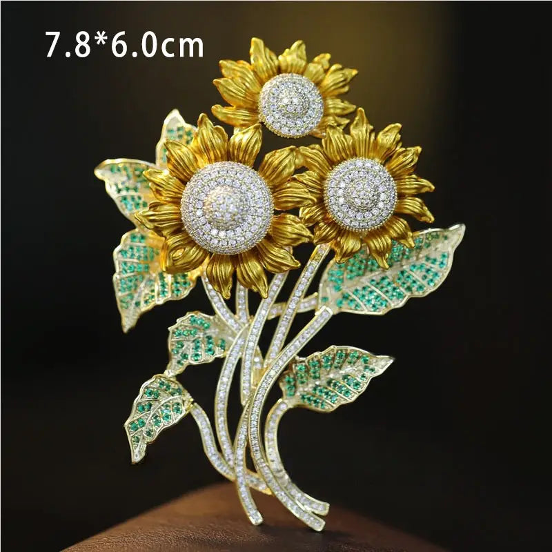 Broche de girasol dorado adornado con diamantes brillantes y gemas verde esmeralda en las hojas de la colección de pin de lujo de diseñador de broche de mariposa de zirconio.