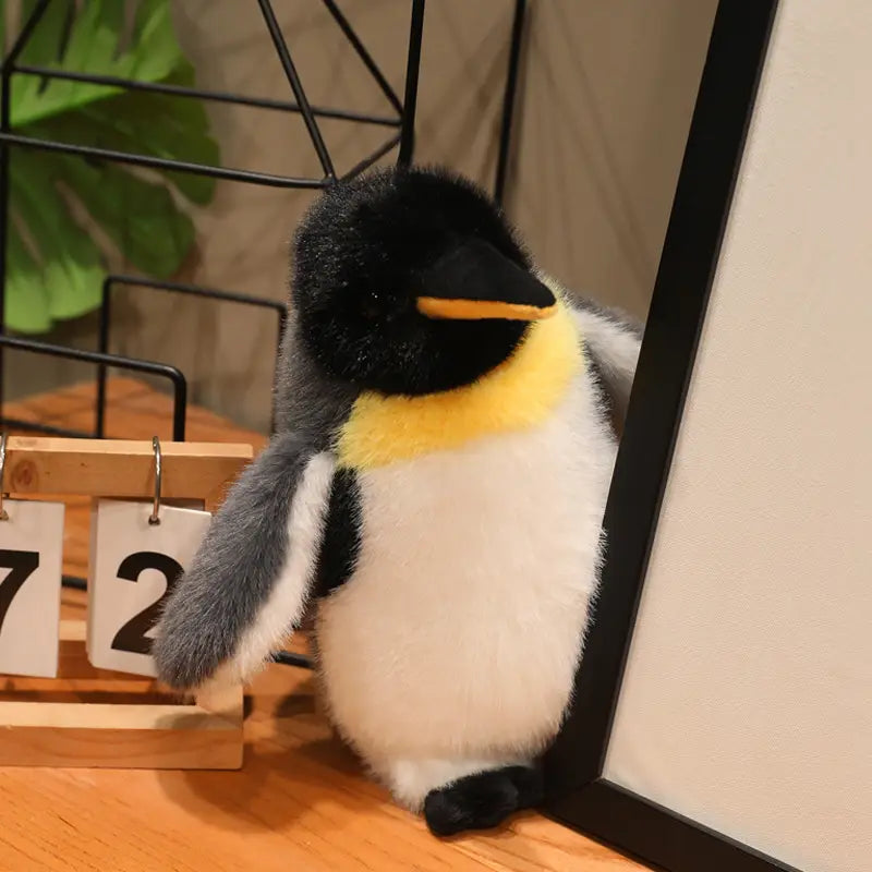 A plush penguin stuffed animal soft toy pair featuring black white and yellow fur made of soft material.