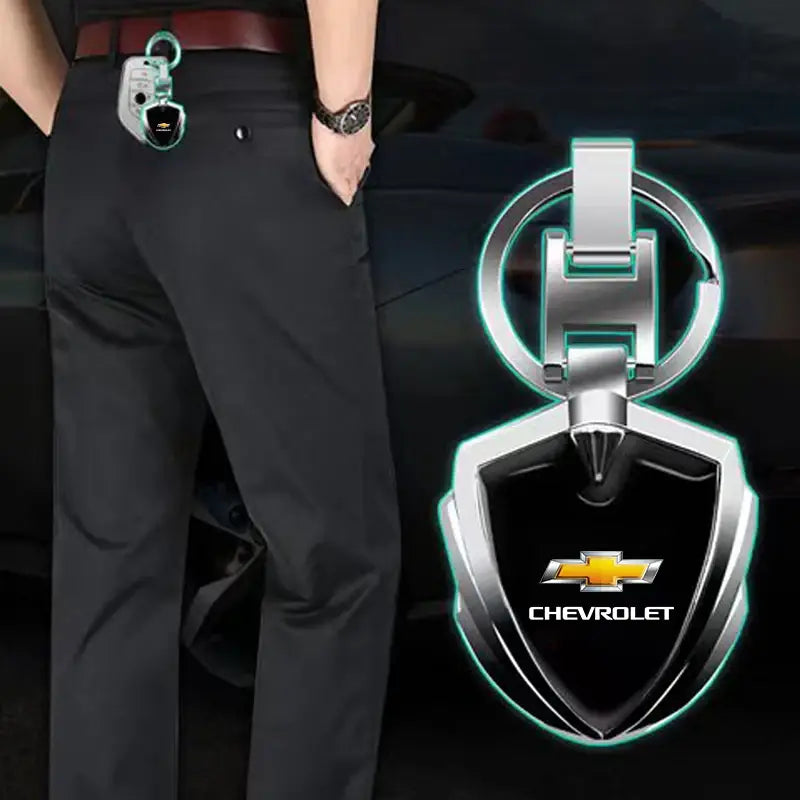 Silver and black Chevrolet metal shield car keychain with chrome finish and shield-shaped design.