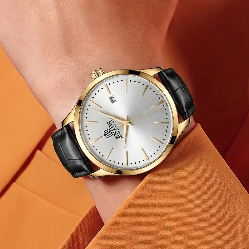 Automatic skeleton mechanical watch featuring a gold-toned case, silver dial with minimalist hour markers, and a black leather strap.