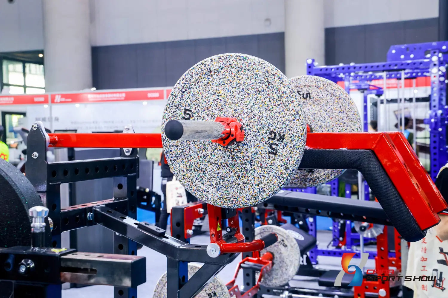 silver speckled weight plates with red collars and black centers mounted on a red barbell rack shown as part of a commercial stair climber machine cardio stepmill setup.
