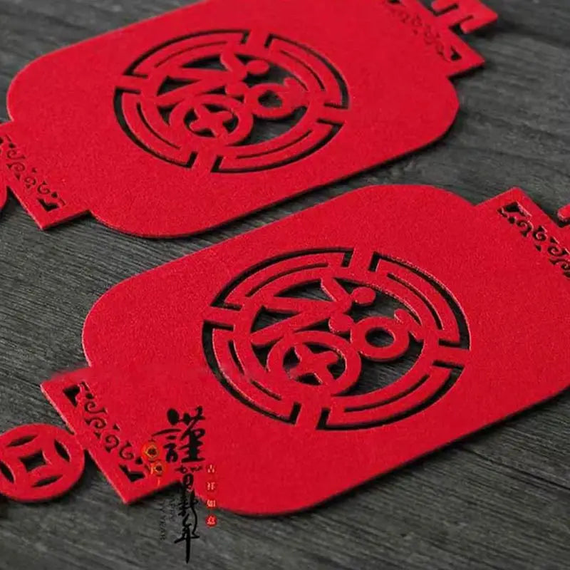 Rote Filz-Laternen-förmige dekorative Ausschnitte mit filigranen schwarzen Laser-Ausschnitt-chinesischen Schriftzeichen und Mustern für die Dekoration zum chinesischen Neujahr als Laternenanhänger.