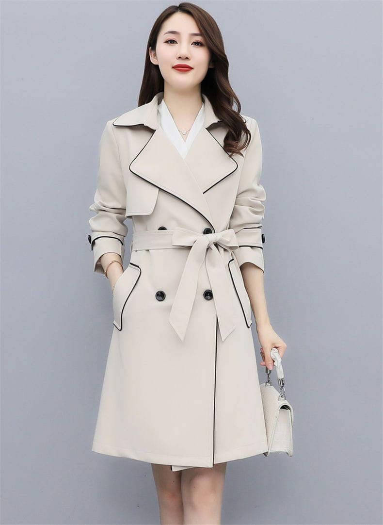 Beige women double breasted trench coat with black trim and a matching belt made from durable material for a sophisticated look.
