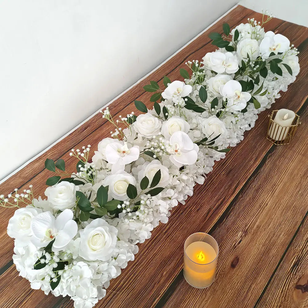 Composition de fleurs de sol pour mariage de rose blanche élégante, présentant une guirlande florale artificielle avec des orchidées, des roses, des hortensias, des feuilles vertes et de la respiration de bébé.