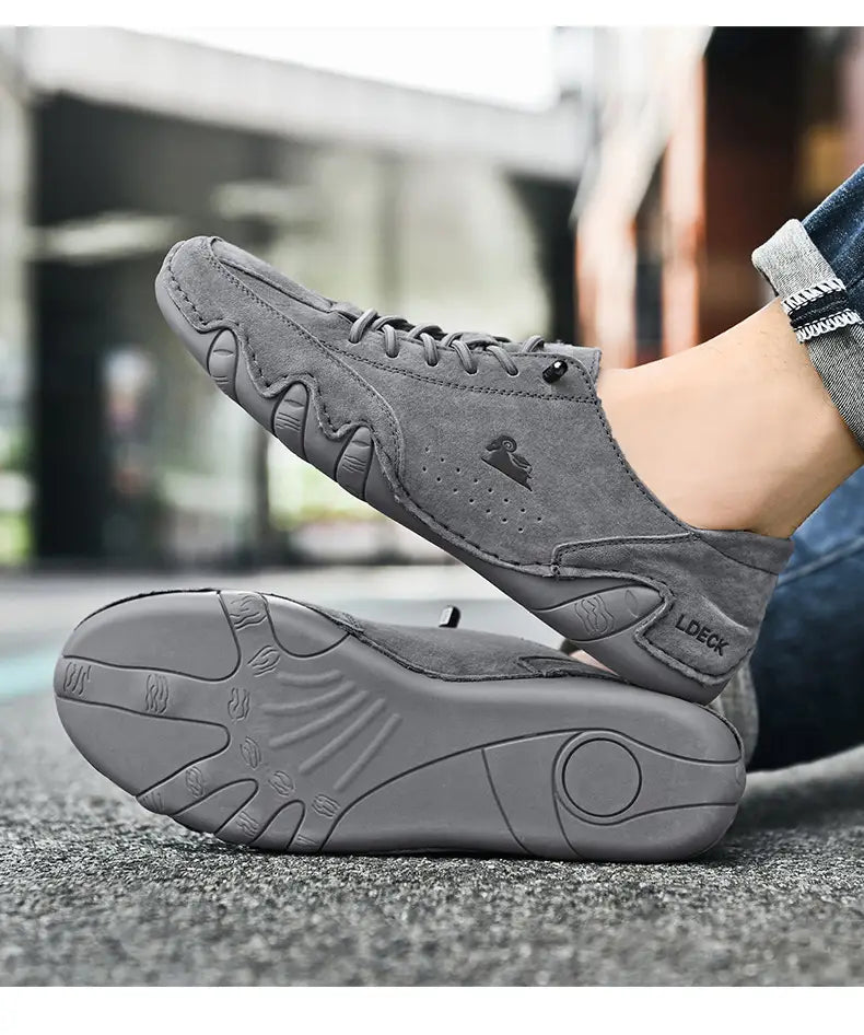 Men high top leather casual sneakers in gray suede with a textured rubber sole and subtle branding on the side.