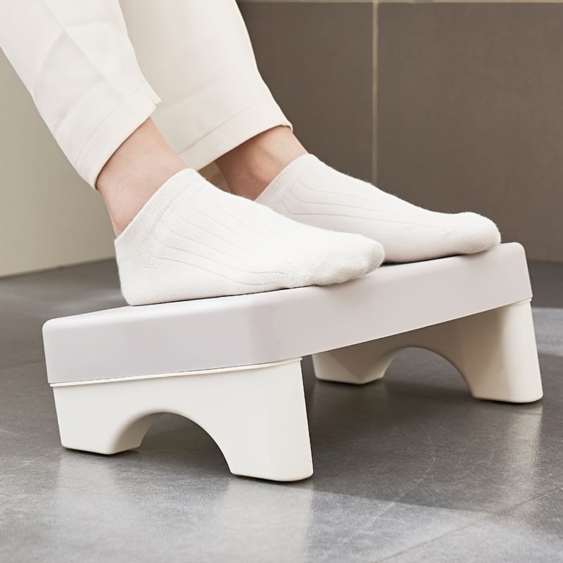White plastic ergonomic under desk footrest with curved supportive legs and a smooth minimalist design