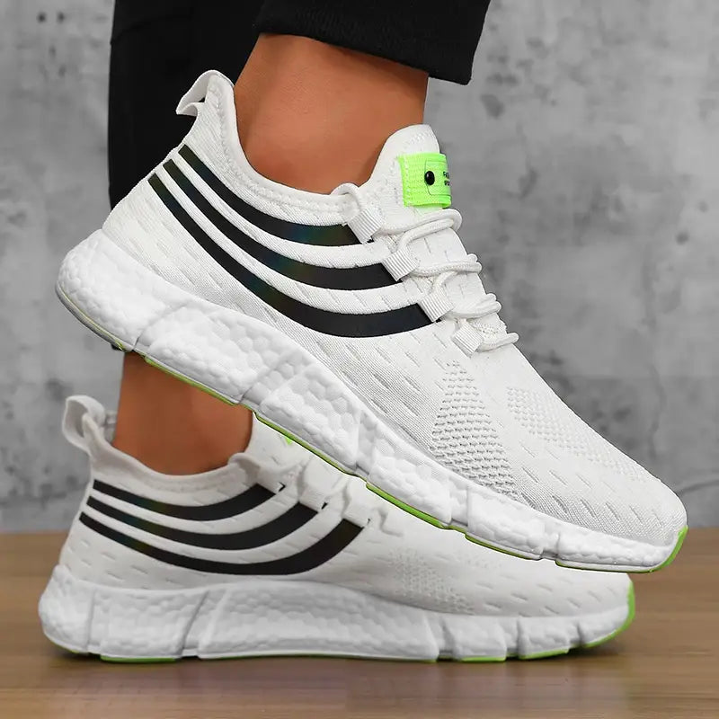 Baskets de sport décontractées en maille respirante pour hommes Zuuban en mesh blanc avec trois bandes « trois bandes » noires et des accents vert néon sur la languette arrière et la semelle.